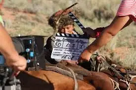 Clapperboard before a take in a scene with a horse